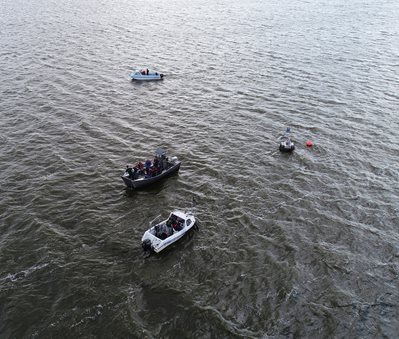 Drone shot from above of the MONOCLE team on boats on the Loch